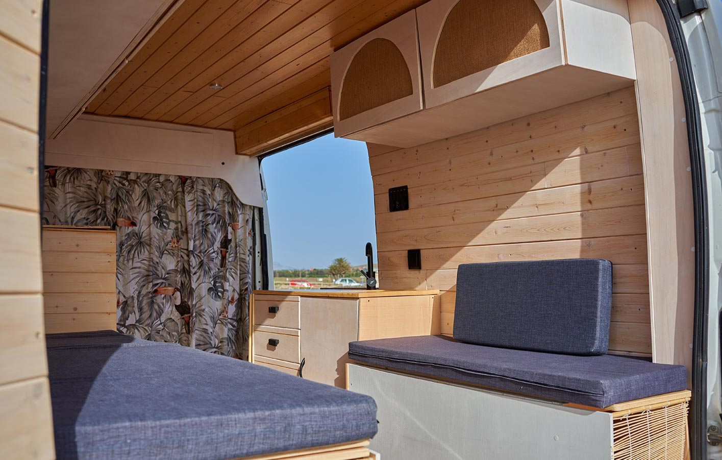 Holzverkleidung im Wohnmobil: Stilvoller und nachhaltiger Innenausbau Wohnmobil-Innenraum mit stilvoller Holzverkleidung, integrierten Sitzflächen und praktischem Stauraum, perfekt für nachhaltige Ausbauprojekte.